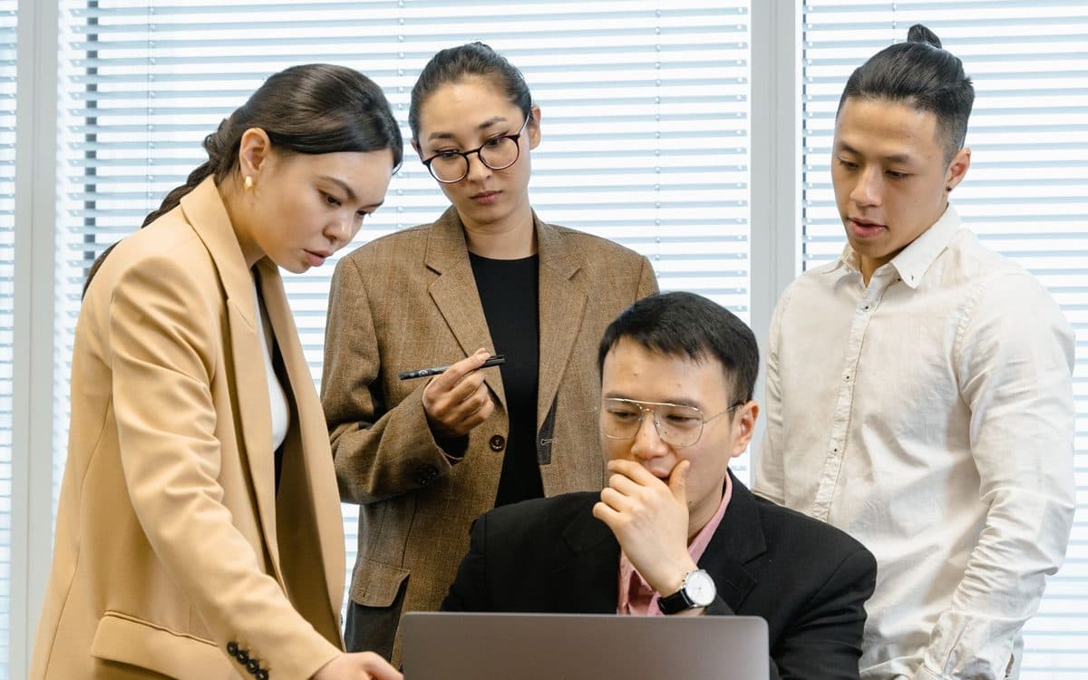 A team reviewing an analysis together around a laptop